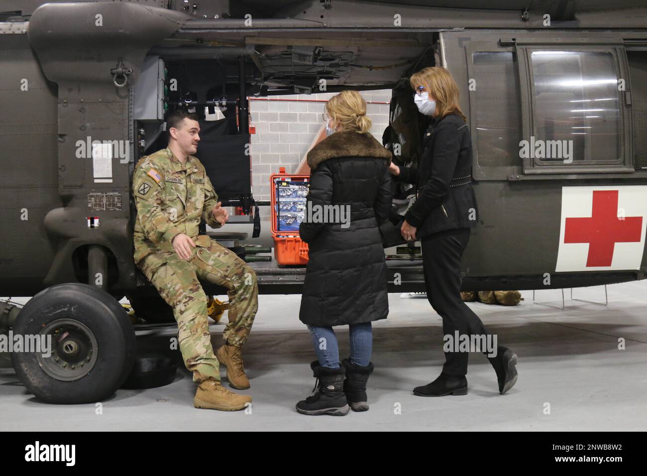 Personale Sgt. Casey Chandler, un medico di volo dell'esercito assegnato a C/3-10 Generale supporto Battaglione Aviazione, 10th Battle Aviation Brigade, 10th Divisione montagna, parla con il Dr. Meja Gray, Direttore medico dei servizi di emergenza e Sarah Delaney, Presidente di Medicina di emergenza, 26 gennaio, a Fort Drum, NY. Chandler ha guidato Gray e Delaney attraverso il materiale di addestramento e le operazioni di volo eseguite dal team MEDEVAC. Foto Stock