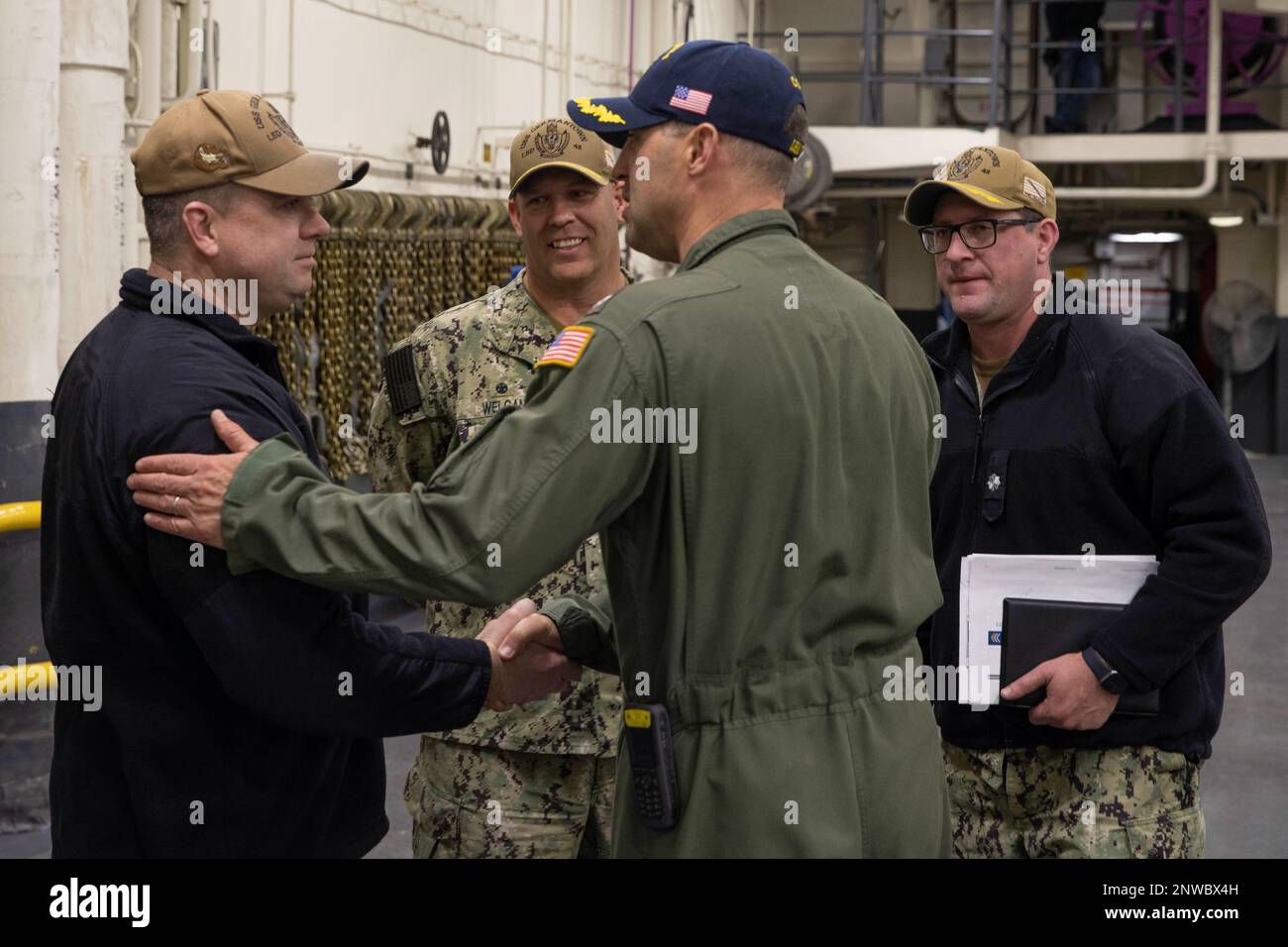 230216-N-EU502-1022 SAN DIEGO (16 febbraio 2023) – il capitano John Kiefaber, comandante del portatore d'assalto anfibio USS Tripoli (LHA 7), al centro, saluta i leader senior della USS Germantown (LSD 42) prima di un breve viaggio a bordo di Tripoli il 16 febbraio. Tripoli è una nave d'assalto anfibio di classe americana ospita a San Diego. Foto Stock