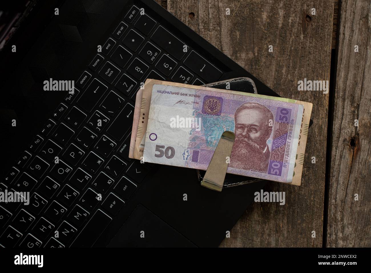 Ucraino 50 UAH denaro in una clip di denaro si trovano su un computer portatile sul tavolo, finanze e lavoro Foto Stock