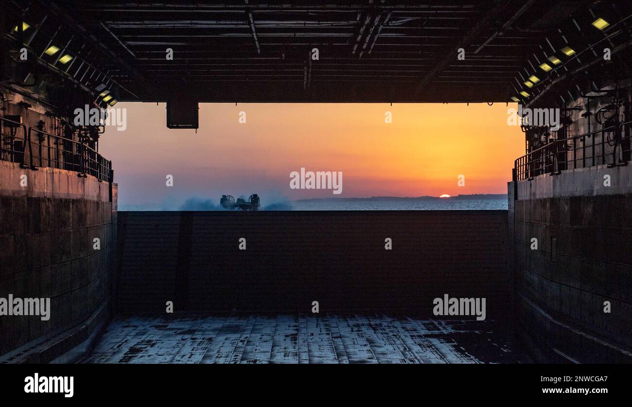 MARE DELLE FILIPPINE (31 gennaio 2023) - Un cuscino d'aria per imbarcazioni da sbarco (LCAC) della Naval Beach Unit (NBU) 7 si prepara ad entrare nel ponte dei pozzi della nave portuale di trasporto anfibio USS Green Bay (LPD 20) durante le operazioni anfibie. Green Bay è presente nell'area operativa della flotta 7th. 7th Fleet è la flotta statunitense La flotta numerata più grande della Marina, distribuita in futuro, interagisce e opera regolarmente con gli alleati e i partner per preservare una regione indomPacifico libera e aperta. Foto Stock