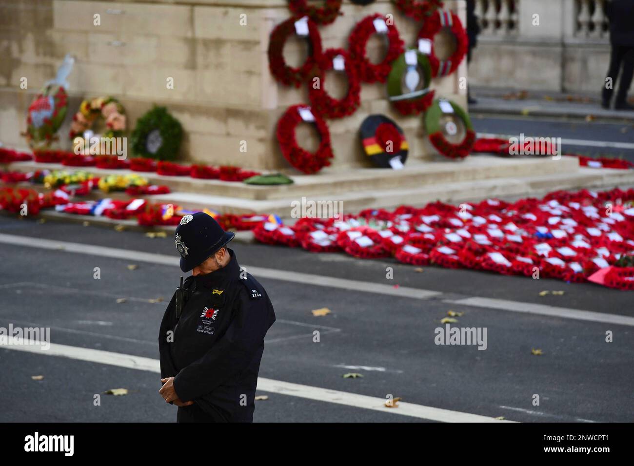 A policeman bows his head with wreaths laid at the Cenotaph during the remembrance service in Whitehall, central London, Sunday Nov. 11, 2018. The ceremony marks the 100th anniversary of the signing of the Armistice which ended the First World War. (Victoria Jones/Pool via AP) Foto Stock
