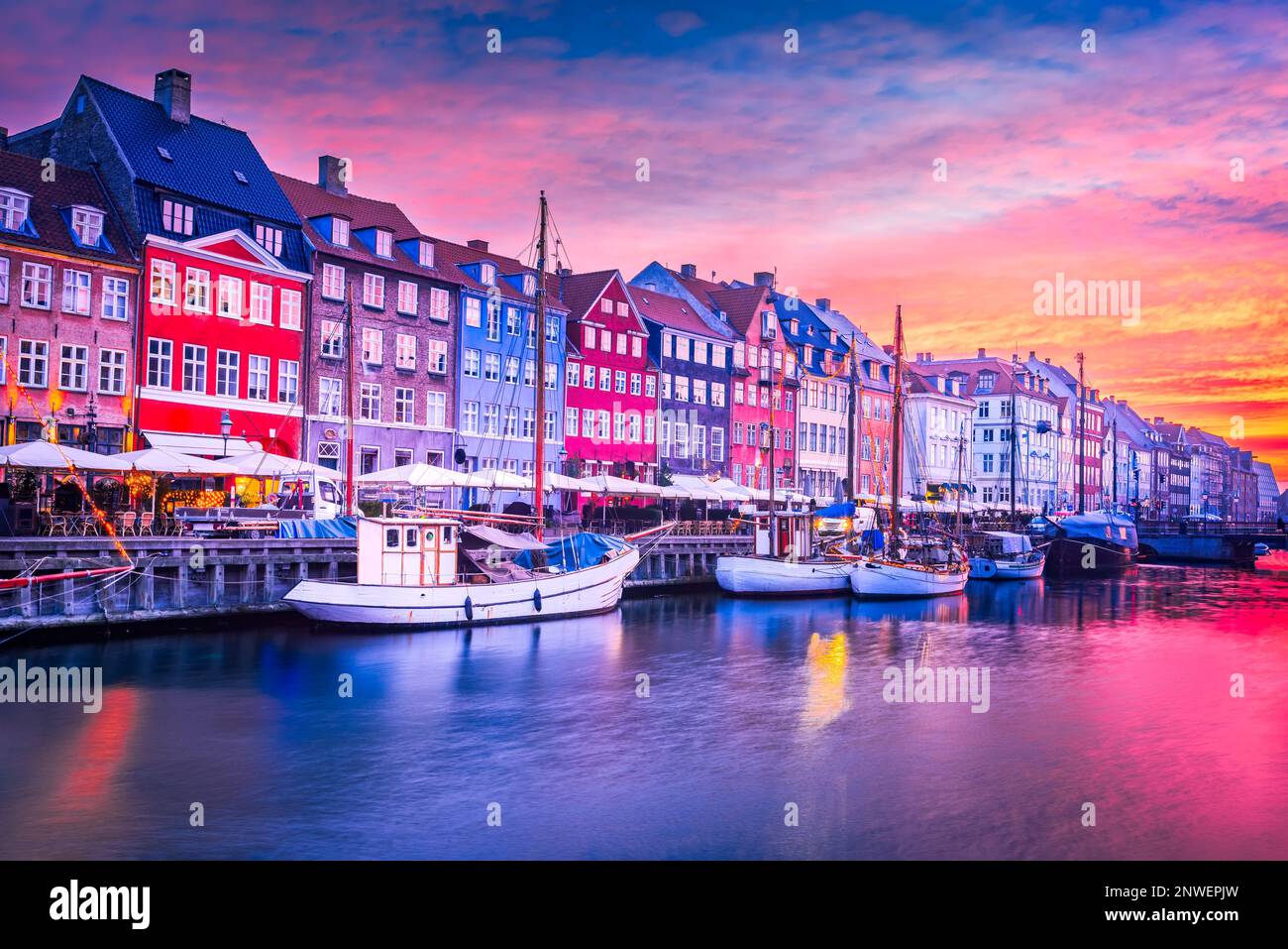 Copenaghen, Danimarca. Bellezza mozzafiato del canale di Nyhavn all'alba, con i suoi iconici edifici colorati e le sue serene riflessioni sull'acqua. Foto Stock