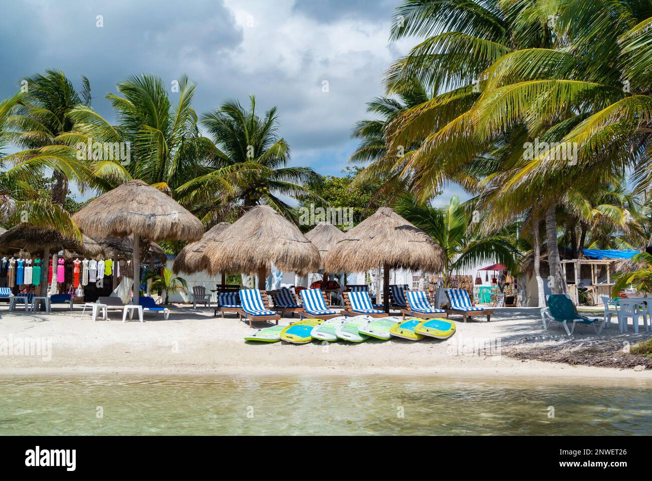 Mahahual, Quintana Roo, Messico, Beach club con lunghe sedie e ombrelloni con palme sulla spiaggia Mahahual Foto Stock