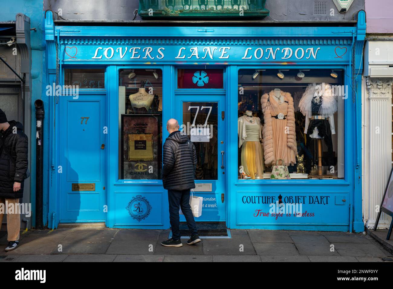 Uomo che guarda la vetrina del negozio d'epoca Lovers Lane designer al 77 Portobello Road nel quartiere di Notting Hill di Londra, Inghilterra Foto Stock