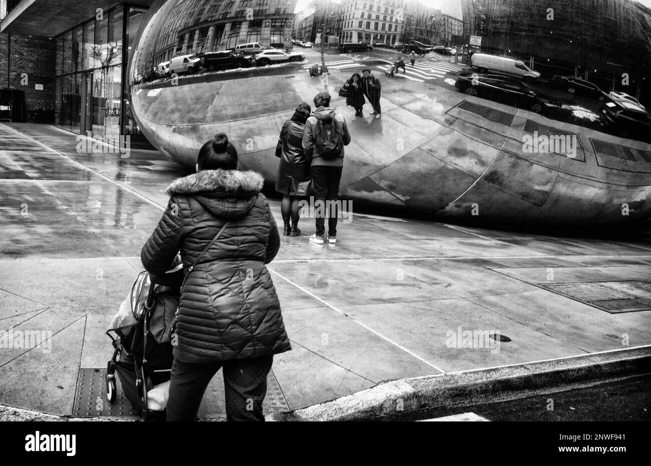 28 febbraio 2023: La gente cammina oltre 'una grande scultura ricurvea e riflettente'' di Anish Kapoor in Lower Manhattan. Pioggia, nevischio e neve con temps negli anni '30 per New York City iThe Weather report di New York City. L'opera, ancora in via di titolo, condivide molte caratteristiche con l'iconica scultura ''Cloud Gate'' dell'artista britannico a Chicago '''' conosciuta colloquialmente come ''The Bean'' questa scultura senza titolo si trova in Church and Leonard Streets a Tribeca (Credit Image: © Brian Branch Price/ZUMA Press Wire) SOLO PER USO EDITORIALE! Non per USO commerciale! Foto Stock