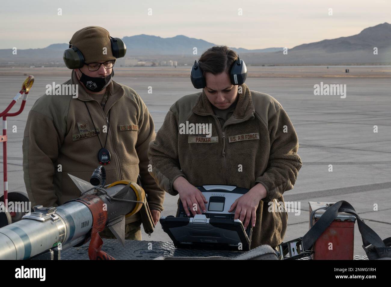 Staff Sgt. Robin Parker, un capo equipaggio addetto al carico di armi assegnato alla 57th Aircraft Maintenance Unit (AMXS), partecipa al concorso annuale Load Crew of the Year in qualità di staff Sgt. Joshua Paulsen, un manutentore assegnato alla 57th AMXS, agisce come arbitro presso la Nellis Air Force base, Nevada, 13 gennaio 2023. Queste competizioni sono parte integrante della tradizione dell'equipaggio di carico e allo stesso tempo costruiscono il morale. Foto Stock