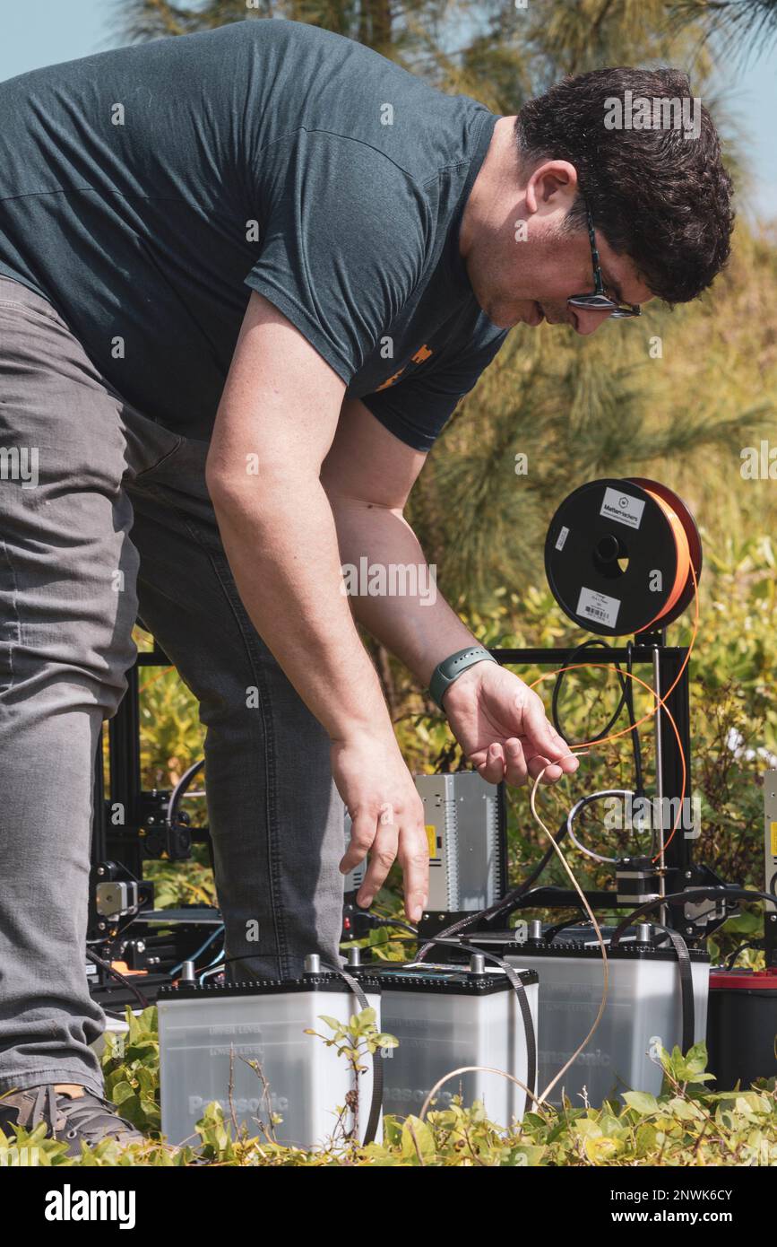 James Bellucci, socio senior di formazione di Building Momentum, ha creato 3D stampanti durante il Boot Camp Innovation a Sea Glass Beach, Okinawa, Giappone, 8 febbraio 2023. I dipendenti di IBC hanno insegnato a Marines competenze quali saldatura, stampa 3D, codifica e programmazione per creare prodotti innovativi per il corpo marino e testare le capacità di pensiero critico di Marines. Foto Stock