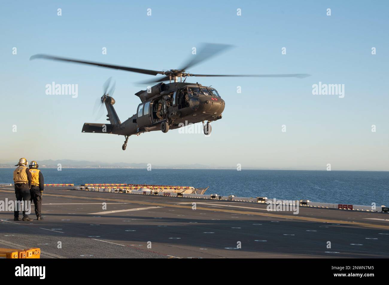 230124-N-XN177-2007 OCEANO PACIFICO (24 GENNAIO 2023) – STATI UNITI Esercito UH-60 elicottero Black Hawk assegnato al combattimento 16th Brigata Aviazione atterra a bordo di un carrier d'assalto anfibio USS Tripoli (LHA 7) 24 gennaio 2023. Tripoli sta conducendo operazioni di routine nella U.S. 3rd Fleet. Foto Stock