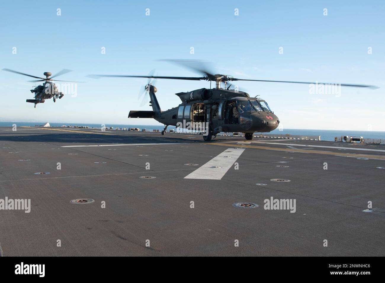 230125-N-XN177-1197 OCEANO PACIFICO (25 GENNAIO 2023) – STATI UNITI Esercito AH-64 elicottero Apache assegnato al combattimento 16th Brigata Aviazione atterra a bordo di un vettore d'assalto anfibio USS Tripoli (LHA 7) 25 gennaio 2023. Tripoli sta conducendo operazioni di routine nella U.S. 3rd Fleet. Foto Stock