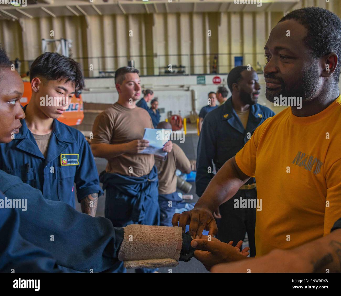 230110-N-TC338-1130 GOLFO DI ADEN (10 gennaio 2023) Engineman 1st Classe Anthony Ashiagbor, da Hanover Park, Ill., a destra, controlla l'impulso di Aviazione Boatswain's Mate (Handling) 2nd Classe Kieara Dexter, da Opelika, Ala., Durante l'addestramento delle 'olimpiadi mediche' nella baia di hangar della base marittima di spedizione della classe di Lewis B. Puller USS Hershel 'Woody' Williams (ESB 4), 10 gennaio 2023. Hershel 'Woody' Williams è in fase di implementazione pianificata negli Stati Uniti Naval Forces Africa area of Operations, impiegato dagli Stati Uniti Sesta flotta per difendere gli interessi degli Stati Uniti, degli alleati e dei partner. Foto Stock