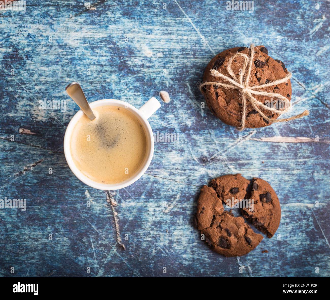 Tazza di caffè caldo fresco, biscotti al cioccolato su vecchio tavolo rustico di legno blu. Sfondo vintage. Caffè mattutino. Caffè caldo, dessert per pranzo. Foto Stock