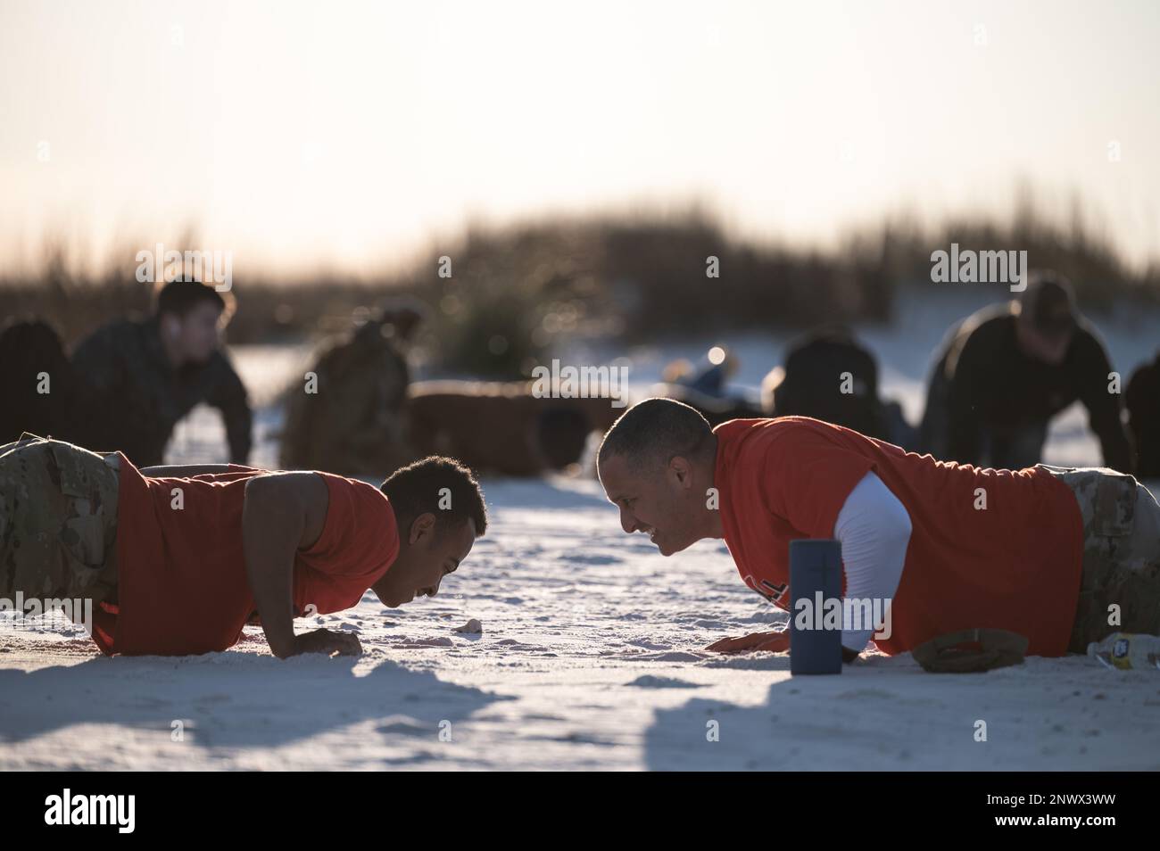 Il Capo Maestro Sgt. Luis Reyes, sovrintendente del 325th Mission Support Group, a destra, dà parole di incoraggiamento a un Airman che esegue i pushup durante un ruck di resilienza alla base dell'aeronautica militare di Tyndall, Florida, 14 febbraio 2023. Reyes crede che la creazione di Airmen resilienti e flessibili debba rimanere una priorità assoluta per i leader, motivo per cui ospita regolarmente scricchi di resilienza di base. Foto Stock