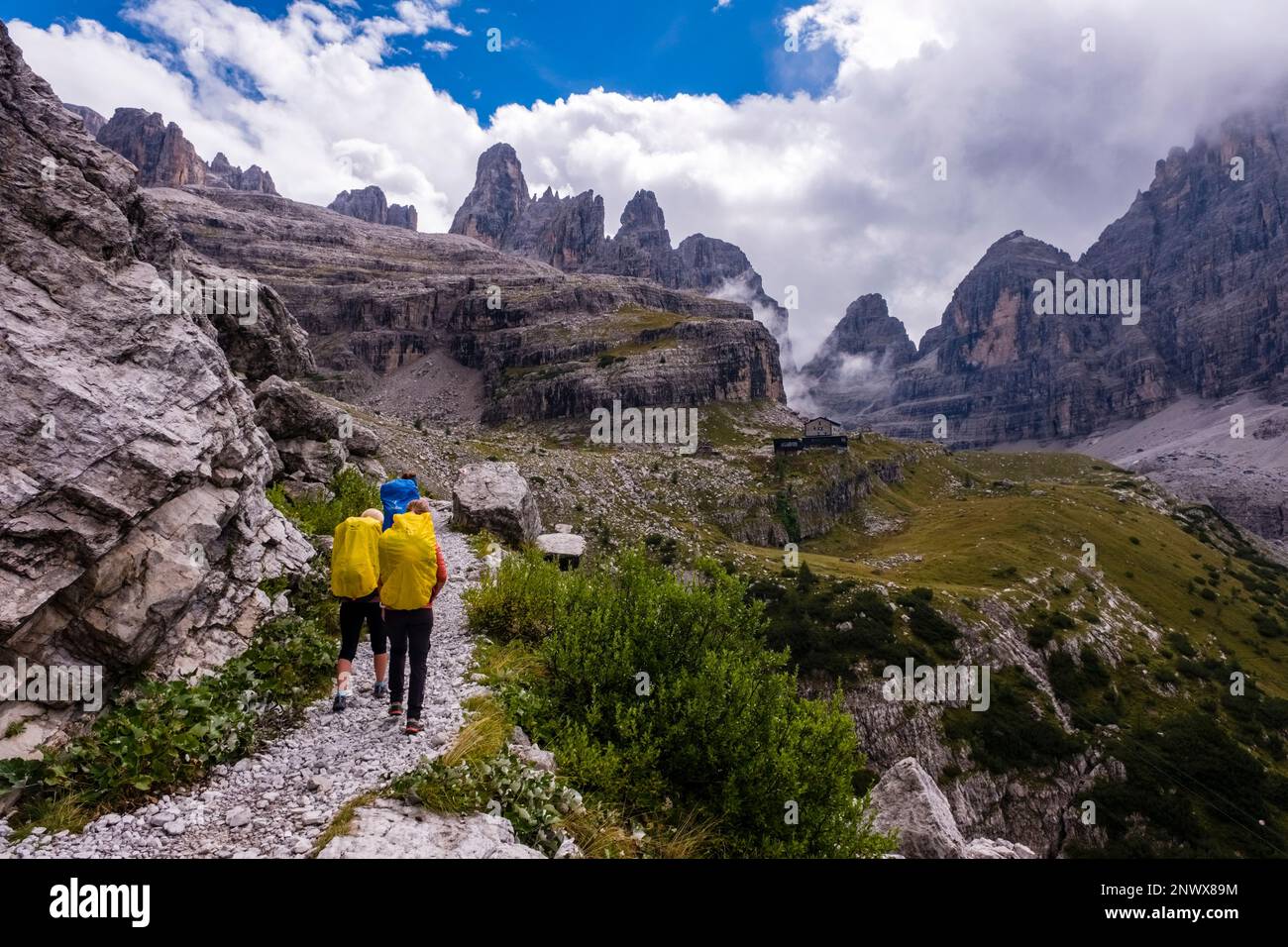 Tre escursionisti che percorrono un sentiero che conduce al rifugio Maria e Alberto al Brentei in Val Brenta nelle Dolomiti di Brenta. Foto Stock