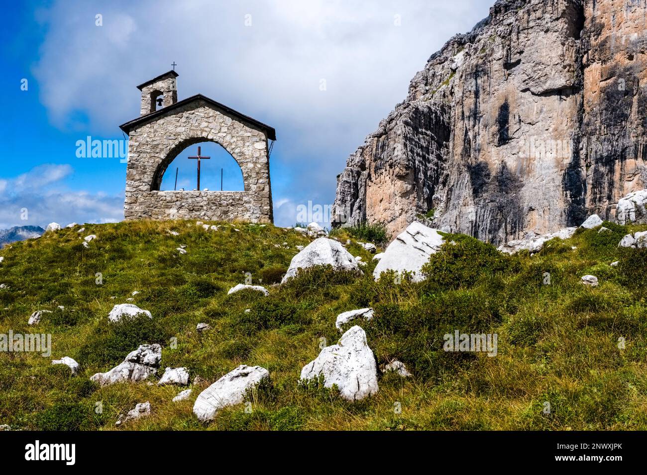 La piccola cappella vicino al rifugio Maria e Alberto al Brentei nelle Dolomiti di Brenta, che circonda in lontananza scogliere rocciose. Foto Stock
