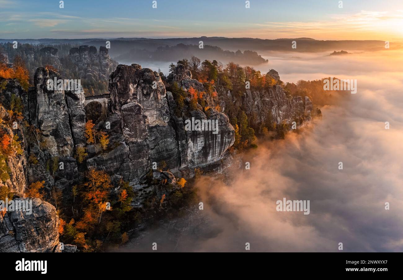 Sassonia, Germania - veduta aerea panoramica del Bastei in una mattina d'autunno nebbia con coloratissime foglie autunnali e nebbia pesante sotto la roccia. Bastei è un Foto Stock