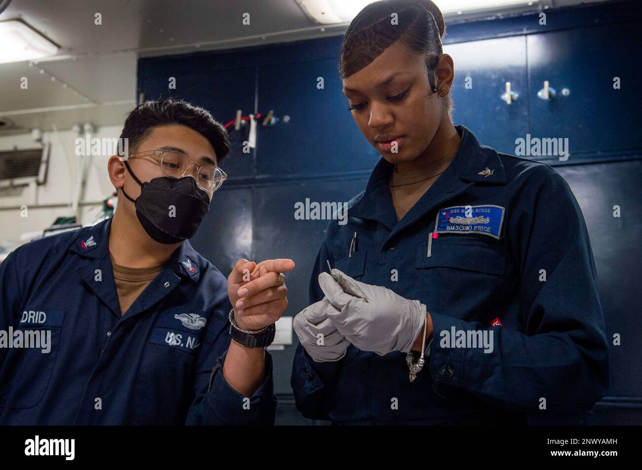 YOKOSUKA, Giappone (25 gennaio 2023) – Hospital Corpsman 3rd Class Raymond Madrid, di Los Angeles, istruisce il compagno di Boatswain 3rd Class Jaela Price, di Birmingham, Alabama, sul modo corretto per ispezionare un ago endovenoso durante un corso di cura della casualità da combattimento tattico a bordo della nave ammiraglia USS Blue Ridge della flotta statunitense 7th (LCC 19), gennaio 25. Il Combat Lifesaver Course fornisce ai marinai un addestramento pratico per assicurarsi di essere pronti a rispondere alle emergenze mediche. Blue Ridge è la più antica nave operativa della Marina e, come 7th Fleet Command nave, interagisce e opera abitualmente con gli Alleati An Foto Stock