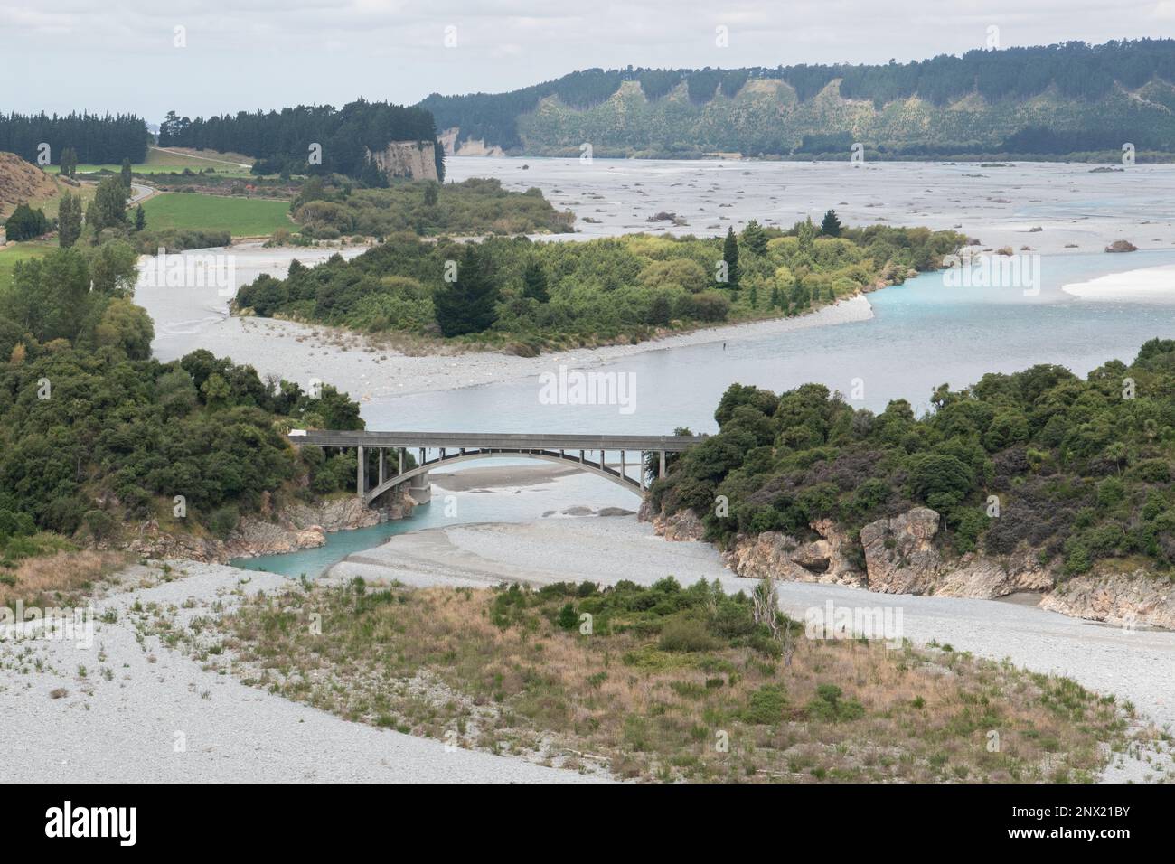 Un'ampia vista panoramica del fiume Rakaia a bassi livelli d'acqua e un ponte su di esso in Nuova Zelanda. Foto Stock