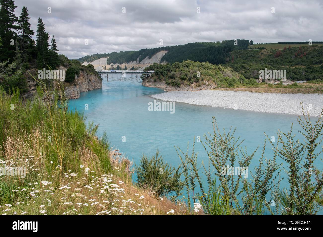 La gola del fiume Rakaia e il paesaggio circostante, un ponte storico passa sopra l'acqua blu costituita da acqua di fusione glaciale in Nuova Zelanda. Foto Stock