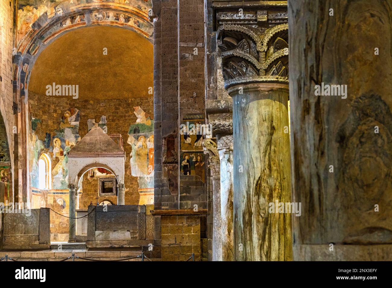 Le navate laterali della Basilica di San Pietro in Tuscania contengono due ciboria e gli affreschi raccontano la storia di Cristo, degli Apostoli e del Battista. Foto Stock