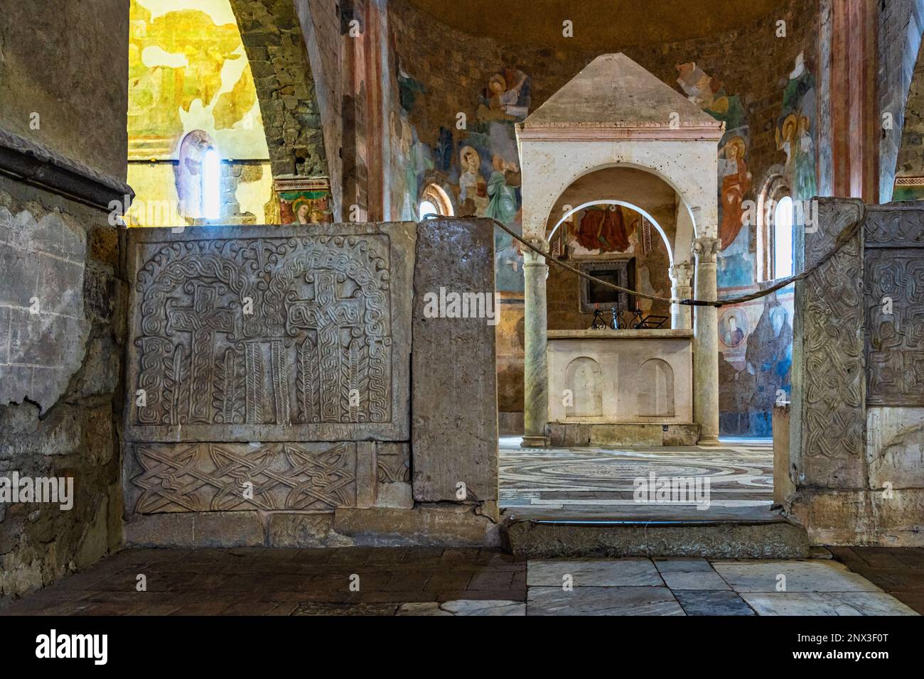 Le navate laterali della Basilica di San Pietro in Tuscania contengono due ciboria e gli affreschi raccontano la storia di Cristo, degli Apostoli e del Battista. Foto Stock