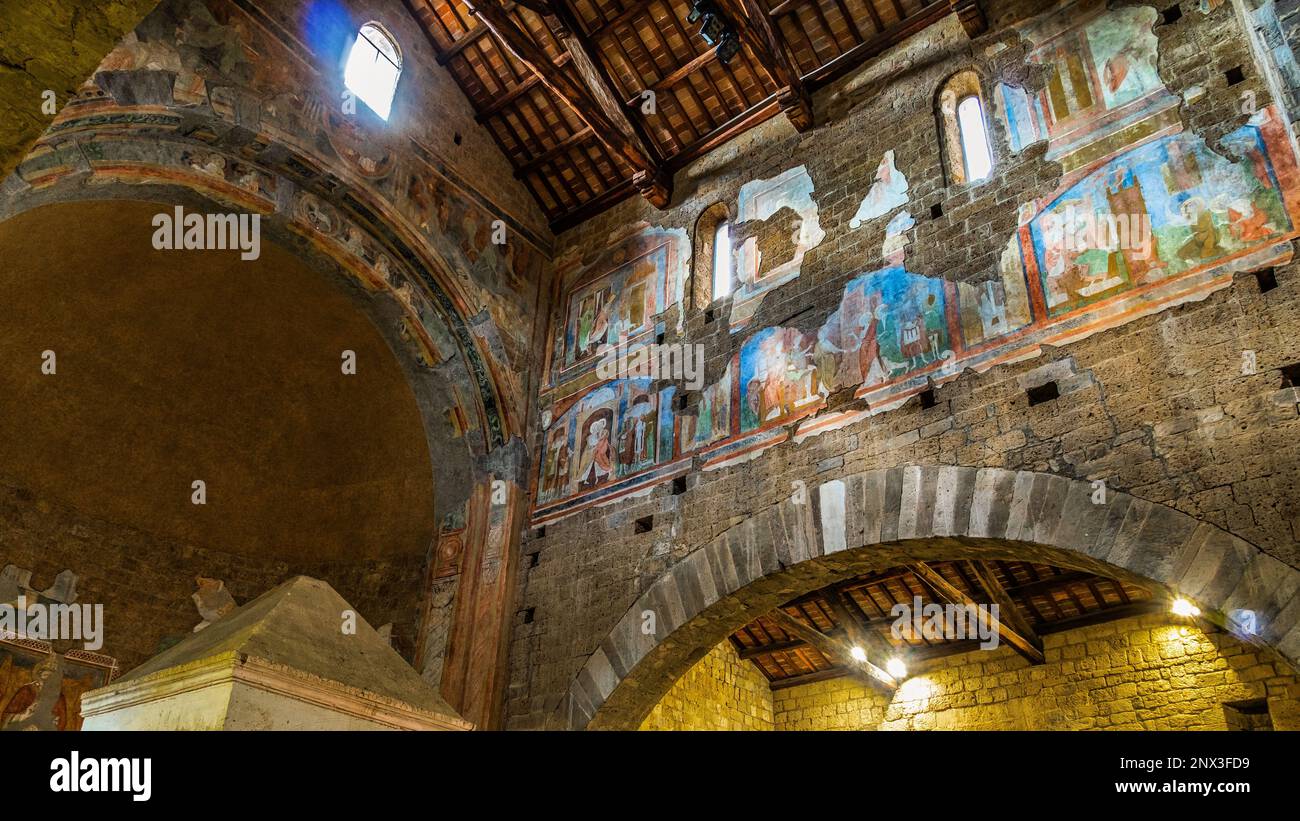 Le navate laterali della Basilica di San Pietro in Tuscania contengono due ciboria e gli affreschi raccontano la storia di Cristo, degli Apostoli e del Battista. Foto Stock
