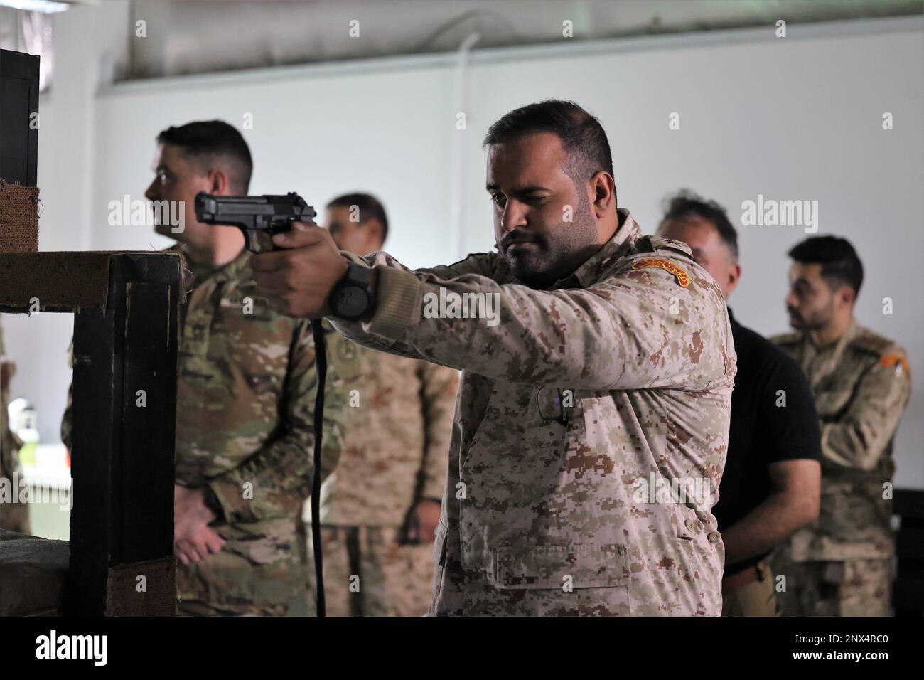 Una piccola coorte della Brigata Armorata del 15th, Kuwait Land Forces, guidata dal Colon. Al-Mekhyal, comandante, visita Camp Arifjan per praticare il tiro al Engagement Skills Trainer, un sistema simile a un videogioco per le abilità con le armi. Il col. Martin Wohlgemuth, comandante, Area Support Group - Kuwait, e il comando Sgt. Major Leon Black, NCOIC, ASG-KU, li ospitano spiegando il valore e il potenziale del sistema EST. Kuwait e soldati americani praticano la M9 pistola e il M4 fucile a Camp Arifjan, Kuwait, 26 gennaio 2023. Foto Stock