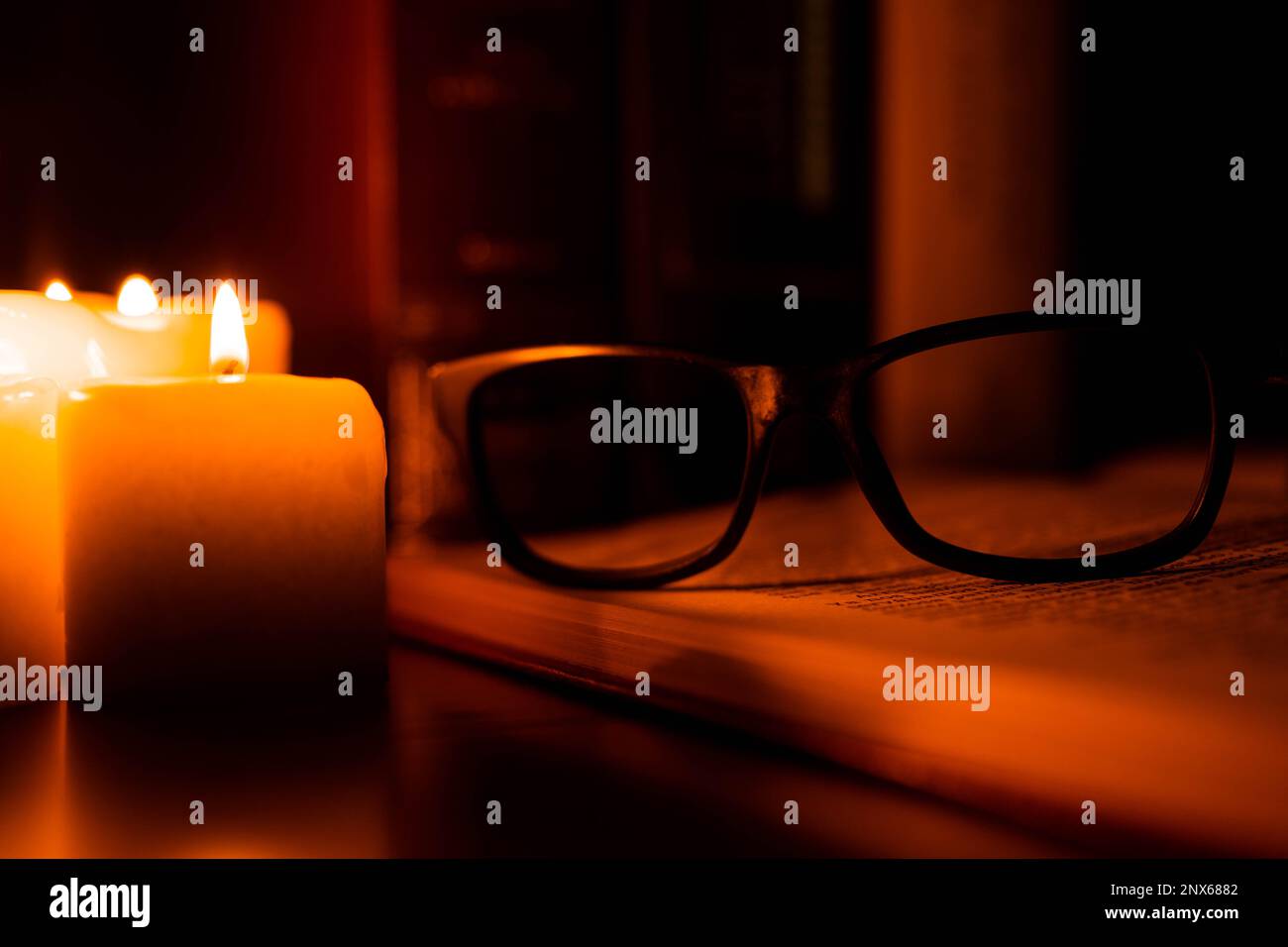 Vita morta di vecchi libri illuminati da un set di candele. Lettura, giorno del Libro, amore per i libri Foto Stock