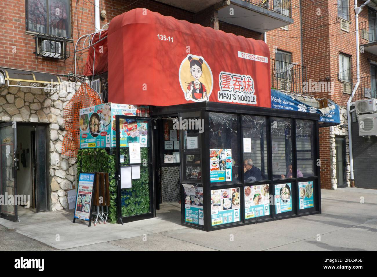L'esterno del Maxi's Noodle, un ristorante in stile Hong Kong con tavoli all'aperto sulla 38th Avenue a Chinatown, Flushing, Queens, New York City. Foto Stock