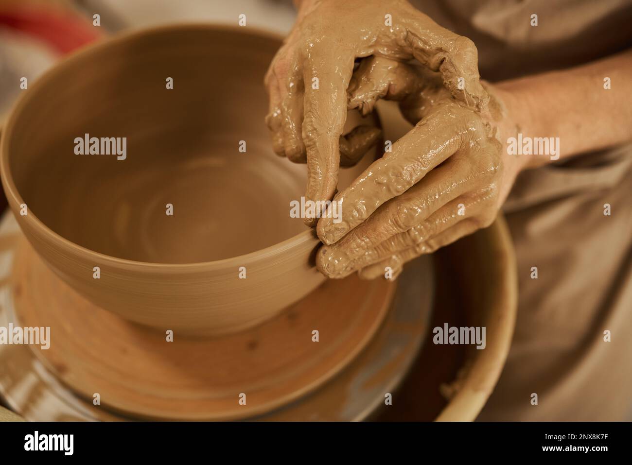 Ceramista fare una ciotola su una ruota in uno studio di ceramica Foto Stock