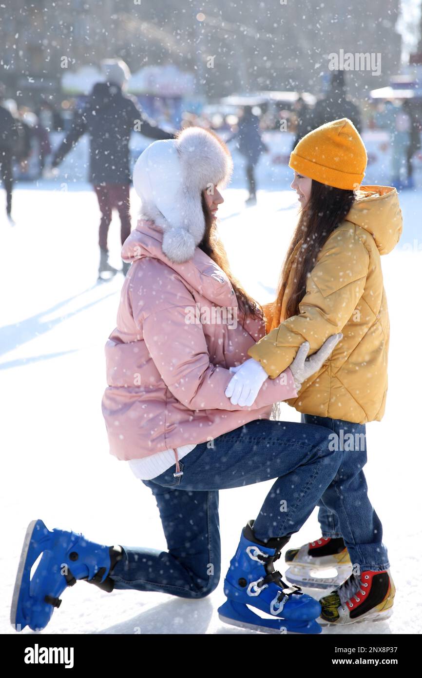 Madre e figlia trascorrono del tempo insieme alla pista di pattinaggio sul ghiaccio all'aperto Foto Stock