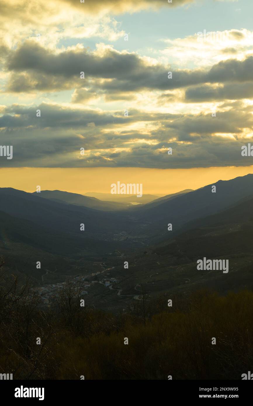 Valle del Jerte dal porto di Tornavacas al tramonto in inverno con cielo con nuvole in verticale Foto Stock Valle del Jerte dal porto di Tornavacas al tramonto in inverno con cielo con nuvole in verticale Foto Stock