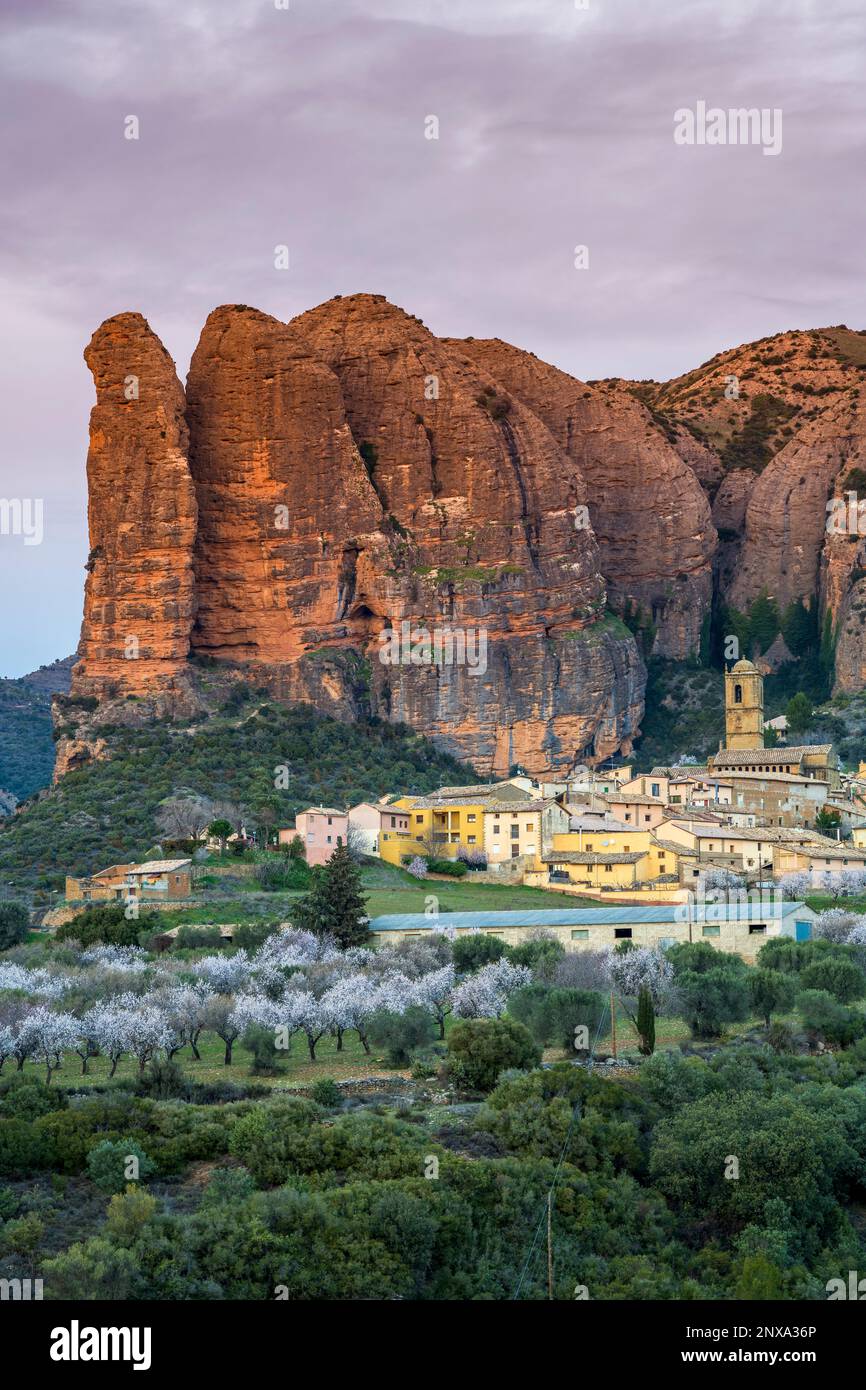 Vista panoramica del villaggio con le formazioni rocciose di Mallos de Aguero dietro, Aguero, Huesca, Aragona, Spagna Foto Stock