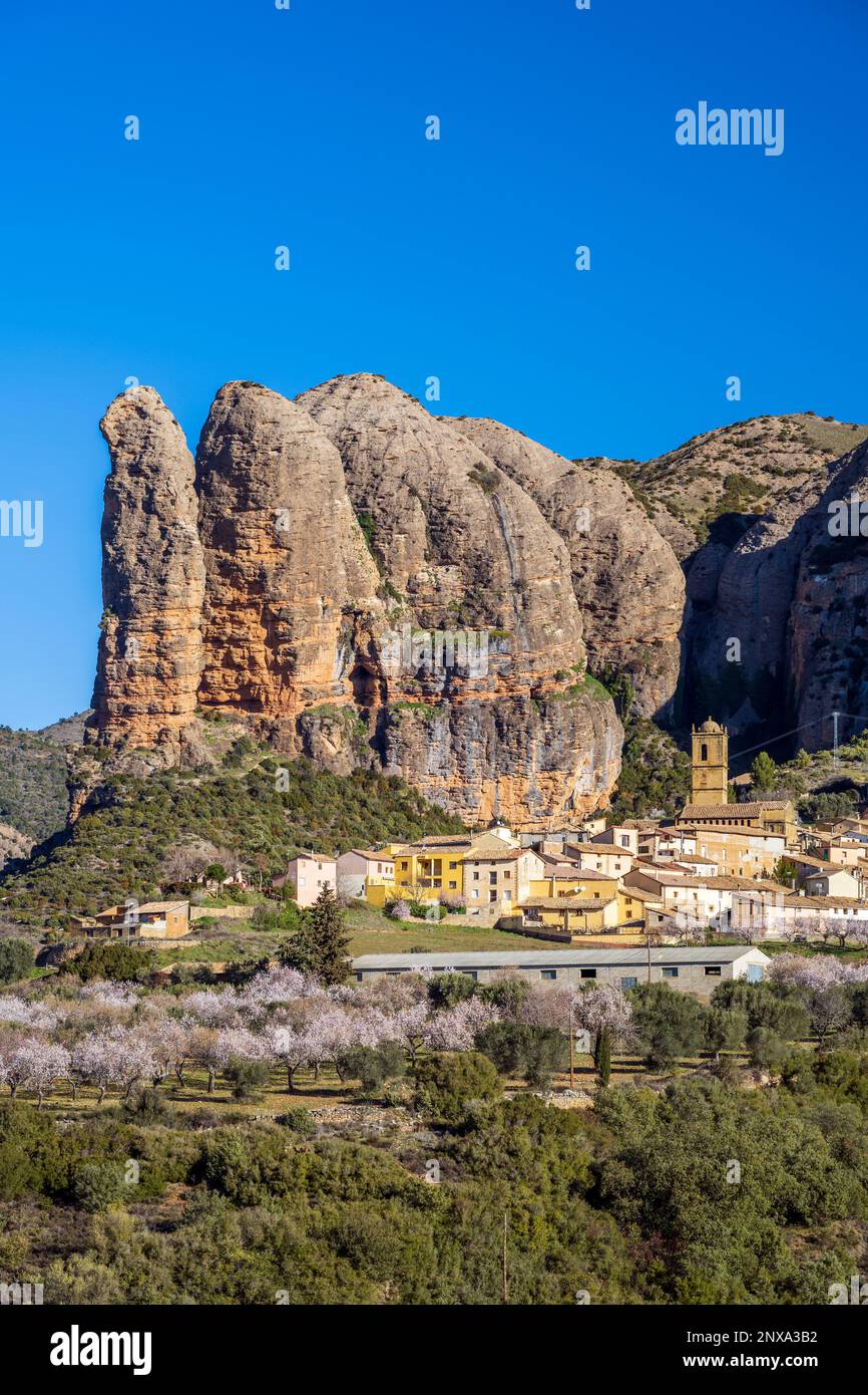 Vista del villaggio con le formazioni rocciose di Mallos de Aguero dietro, Aguero, Huesca, Aragona, Spagna Foto Stock