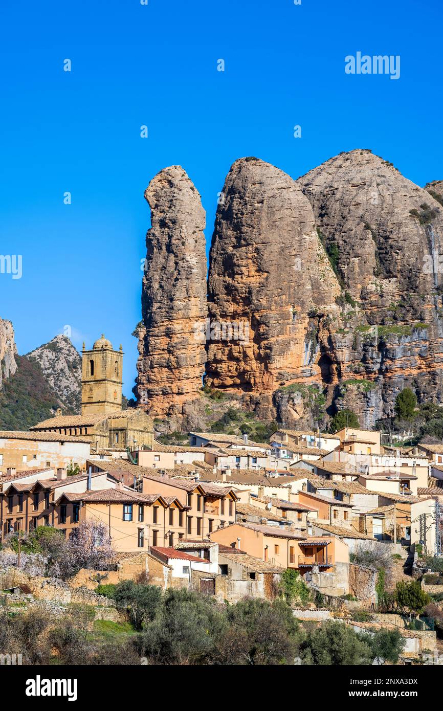 Vista del villaggio con le formazioni rocciose di Mallos de Aguero dietro, Aguero, Huesca, Aragona, Spagna Foto Stock