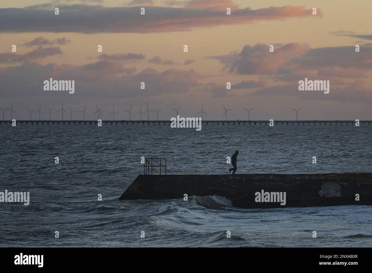 Walton al tramonto di Naze. Vista sugli interruttori a onde. Toni caldi del sole. Le onde si schiantano. Giorno ventoso. Foto Stock