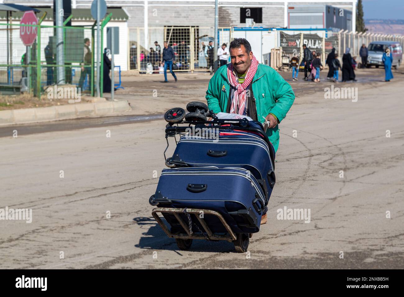 I rifugiati siriani ritornano nella zona sicura del suo paese. I rifugiati siriani trasportano i loro bagagli in un carrello per magazzini. Foto Stock