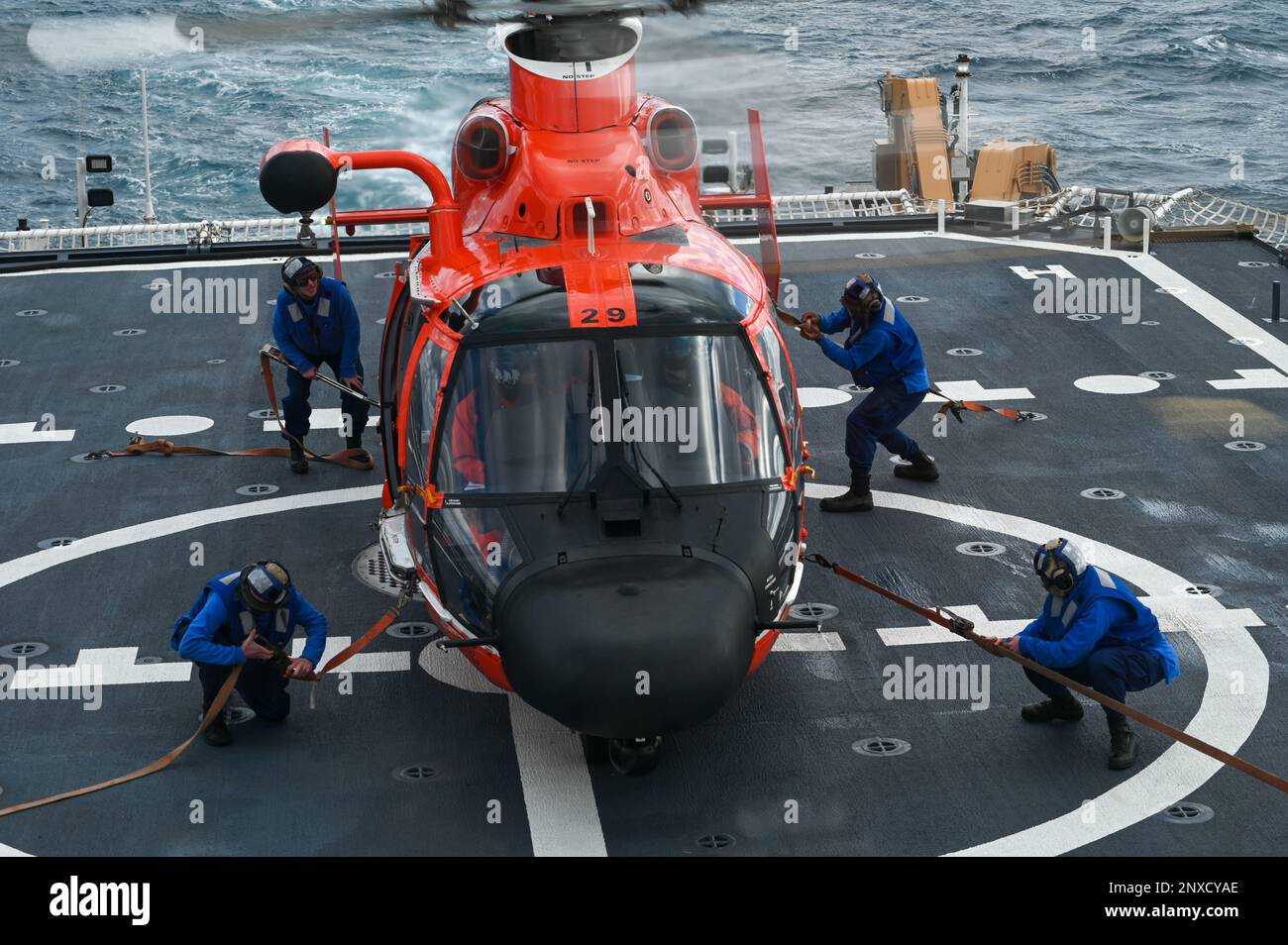 L’equipaggio della USCGC Stone (WMSL 758) assicura un elicottero Helicopter Interdiction Tactical Squadron MH-65 Dolphin al ponte di volo della Stone nell’Oceano Atlantico, 13 gennaio 2023. Stone è su un dispiegamento programmato di più missioni nell'Atlantico meridionale per contrastare le attività marittime illecite e rafforzare le relazioni per la sovranità marittima in tutta la regione. Foto Stock