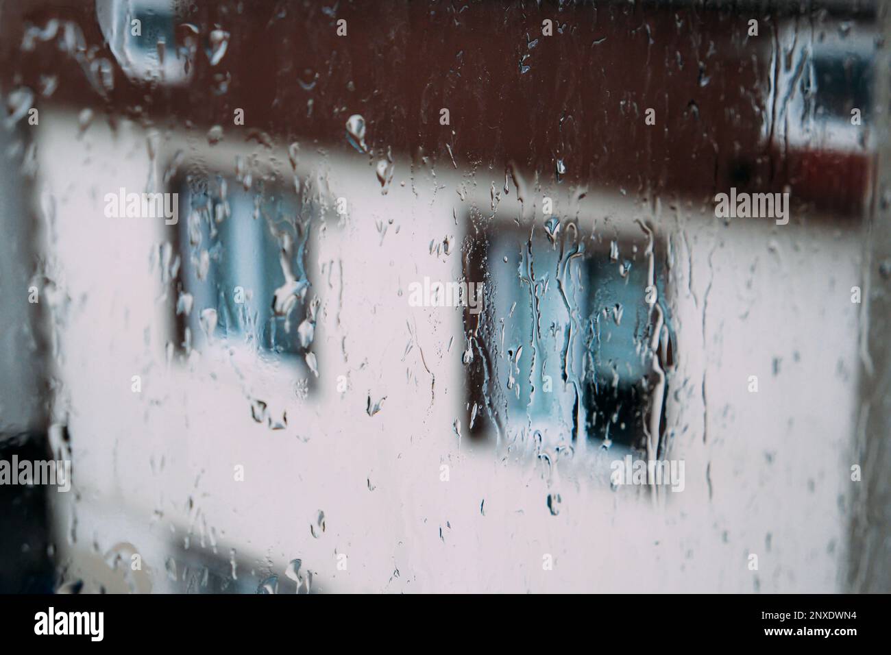Goccioline di pioggia su una superficie trasparente del vetro del finestrino. Gocce sulla protezione della finestra in una giornata piovosa. Tempo tempesta. Isolamento, triste concetto di depressione. Piovoso s Foto Stock