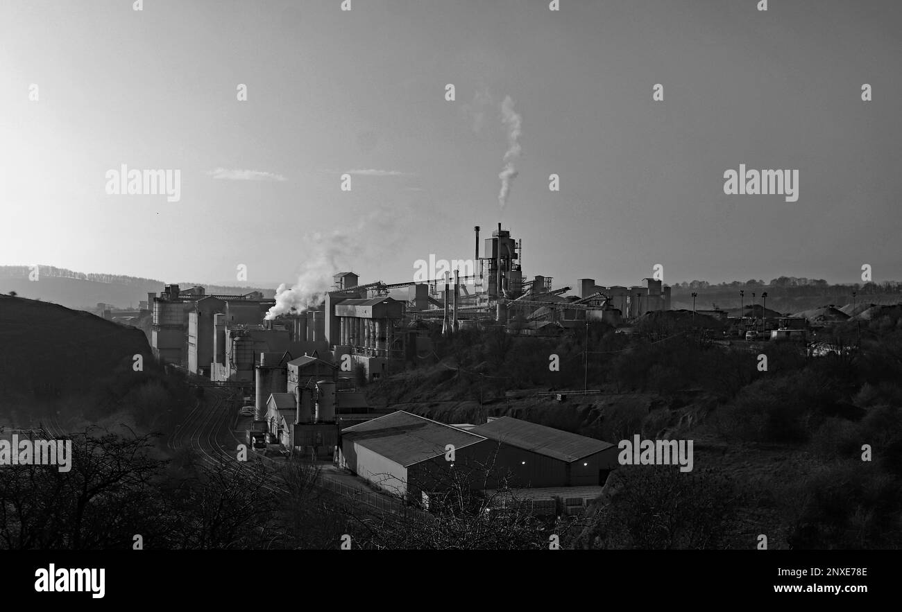 Un'immagine in bianco e nero del calcare di Tarmac lavora a Tunstead, dove i pennacchi di vapore stanno andando quasi dritti Foto Stock