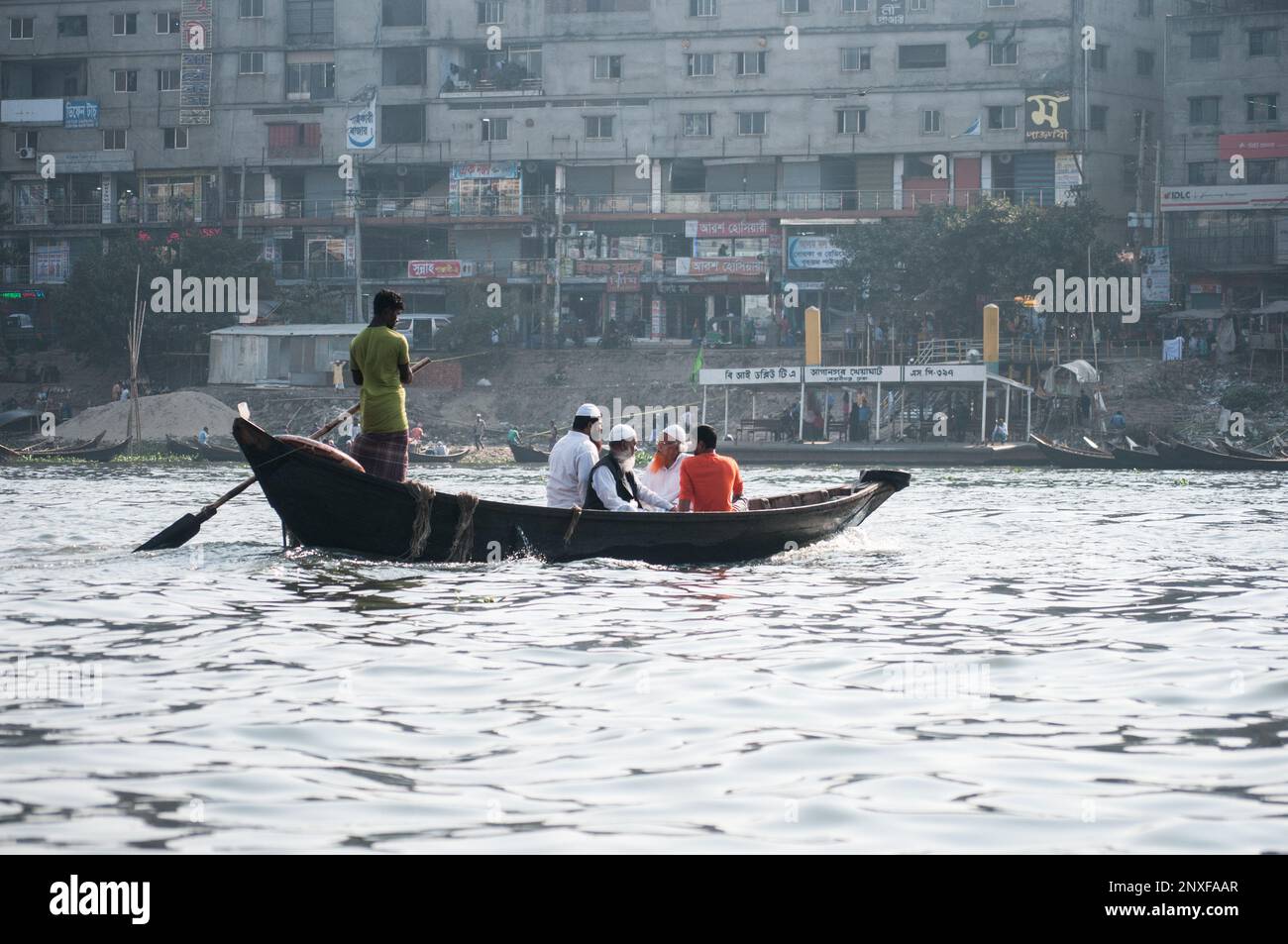 Foto della barca sull'acqua a Sadarghat e vista sulla strada. Alcuni venditori di fiori a Dhaka, Bangladesh Foto Stock