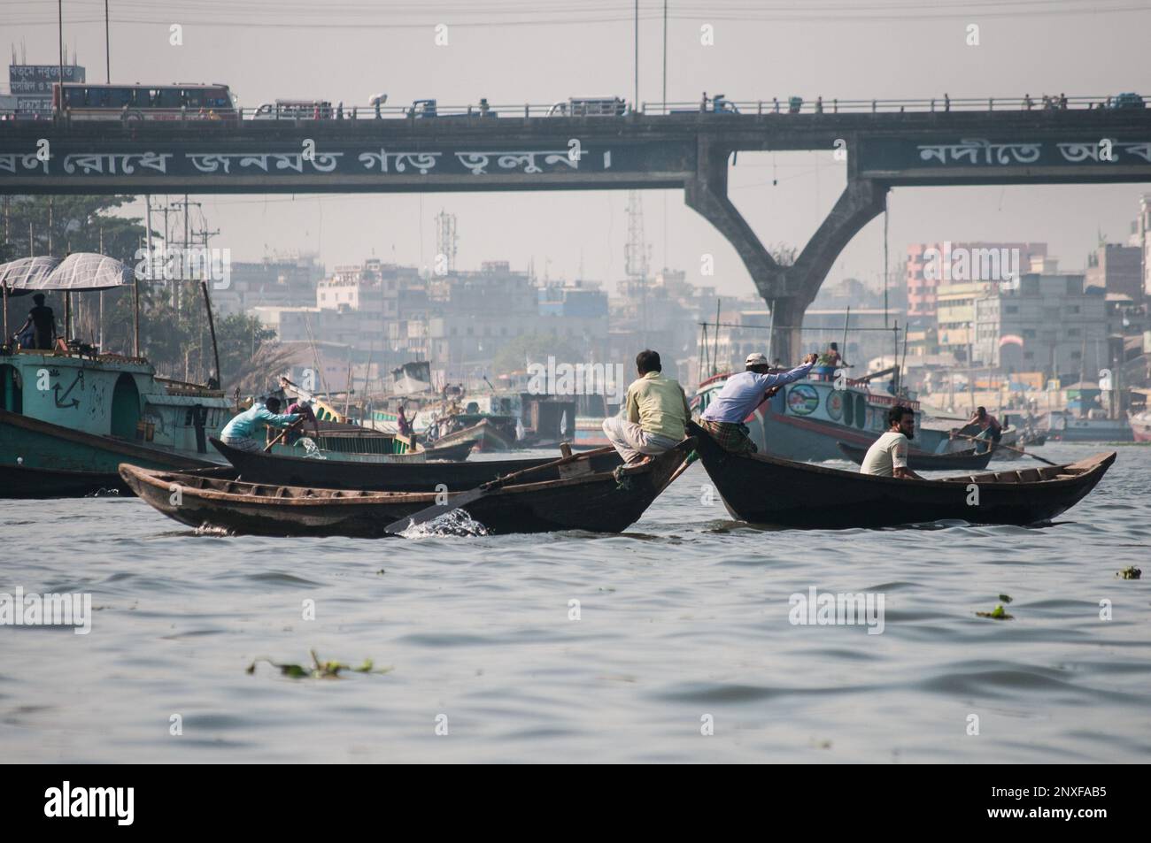 Foto della barca sull'acqua a Sadarghat e vista sulla strada. Alcuni venditori di fiori a Dhaka, Bangladesh Foto Stock