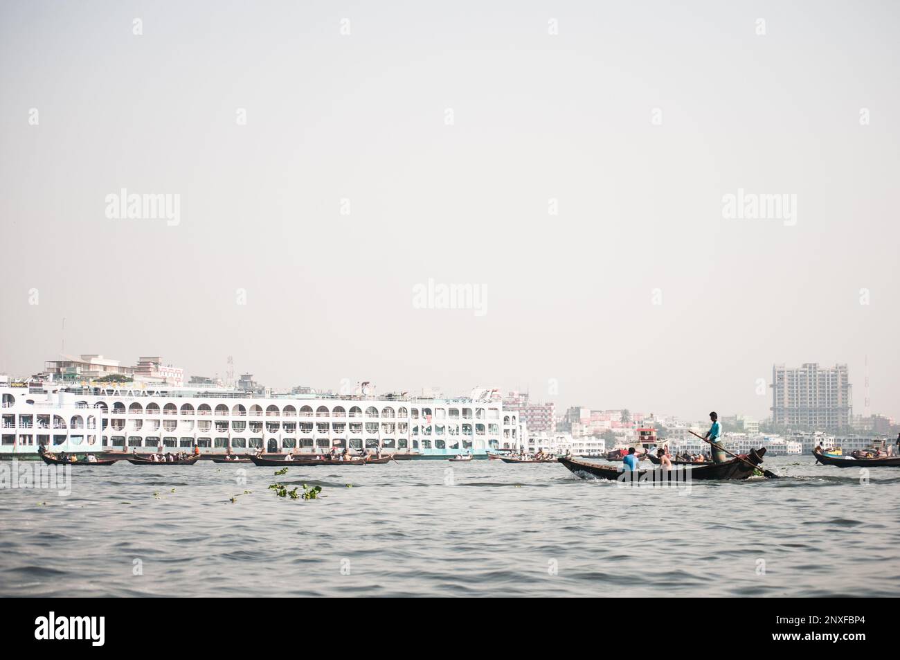 Foto della barca sull'acqua a Sadarghat e vista sulla strada. Alcuni venditori di fiori a Dhaka, Bangladesh Foto Stock
