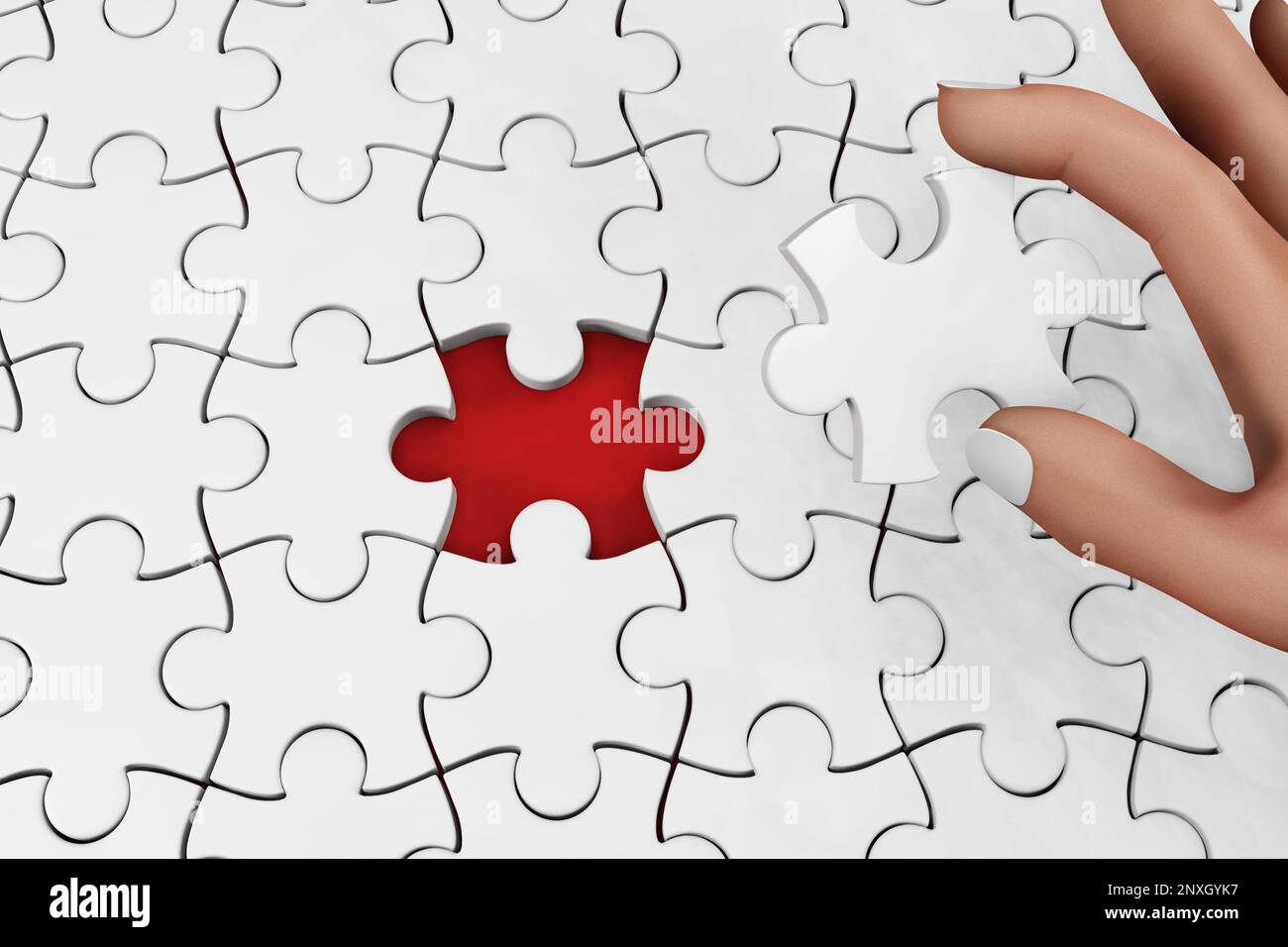 Una mano che tiene un pezzo di puzzle andando a completare un puzzle. Illustrazione del concetto di realizzazione e completamento e come spazio di copia Foto Stock