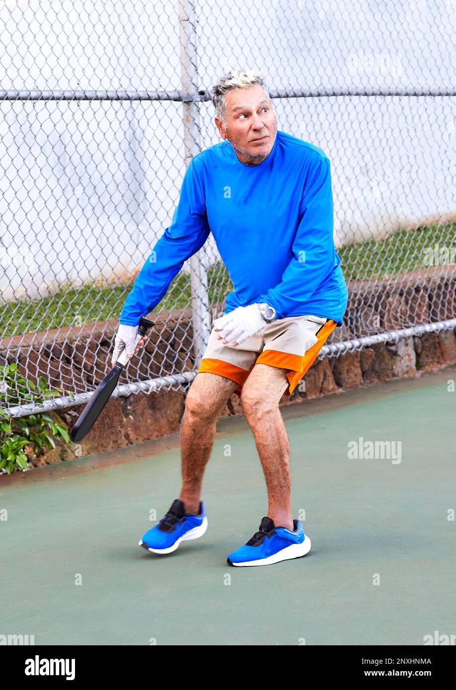 Uomo anziano attivo che gioca a Pickle Ball all'aperto Foto Stock