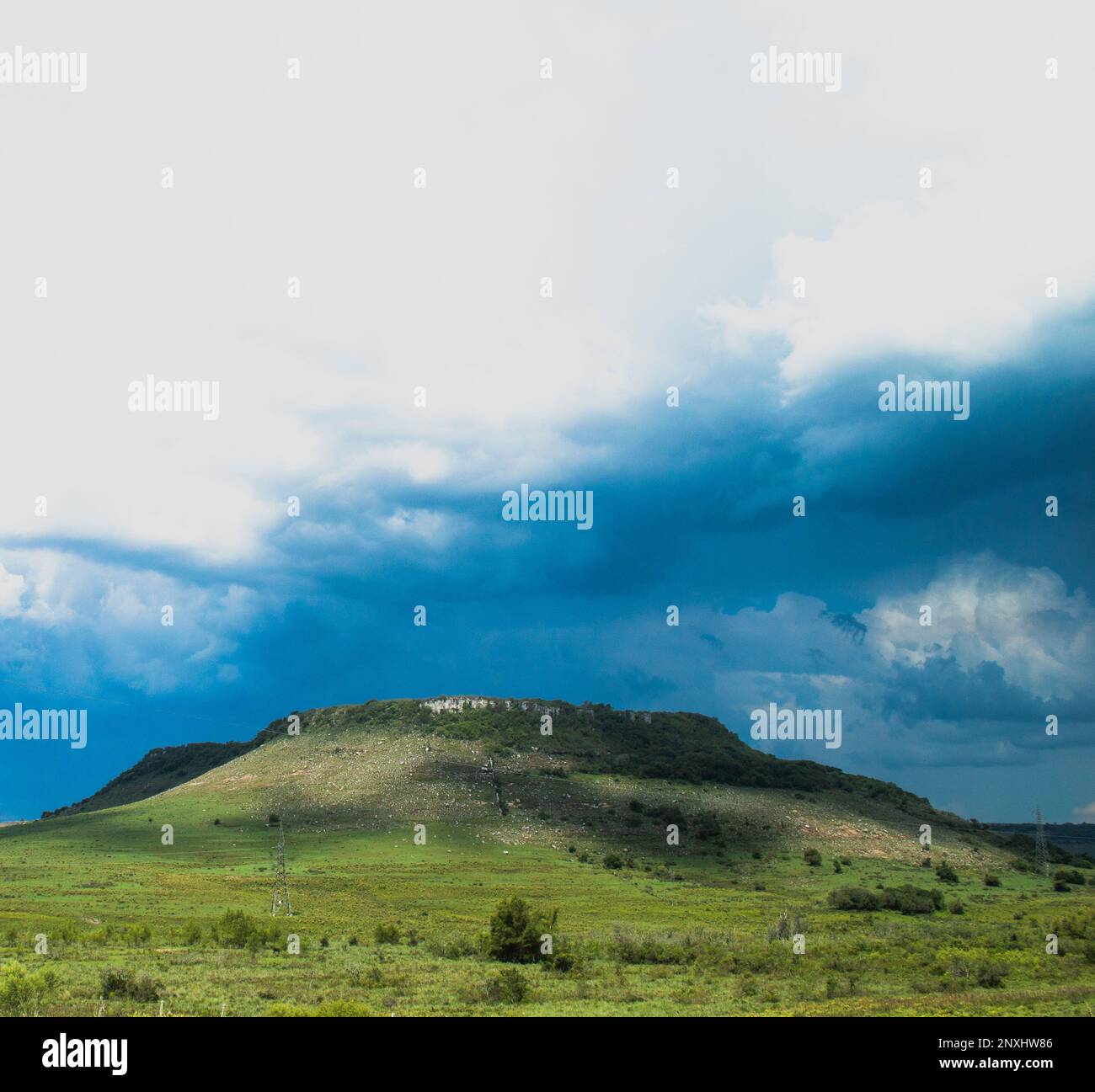 Bellissima vista del tipico piano superiore colline nord Uruguay. Parte verde in giù con parte superiore grigia in pietra. cielo azzurro soleggiato e nuvole tempesta in un'immagine impattante Foto Stock