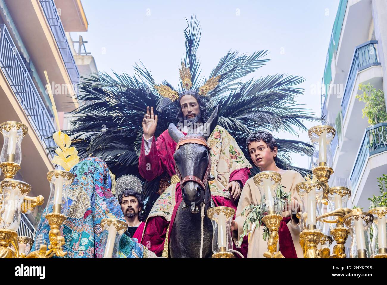 Cristo cavalcando un asino nel Trono o piattaforma della Confraternita della Borriquita, in processione per le strette stradine della città Foto Stock