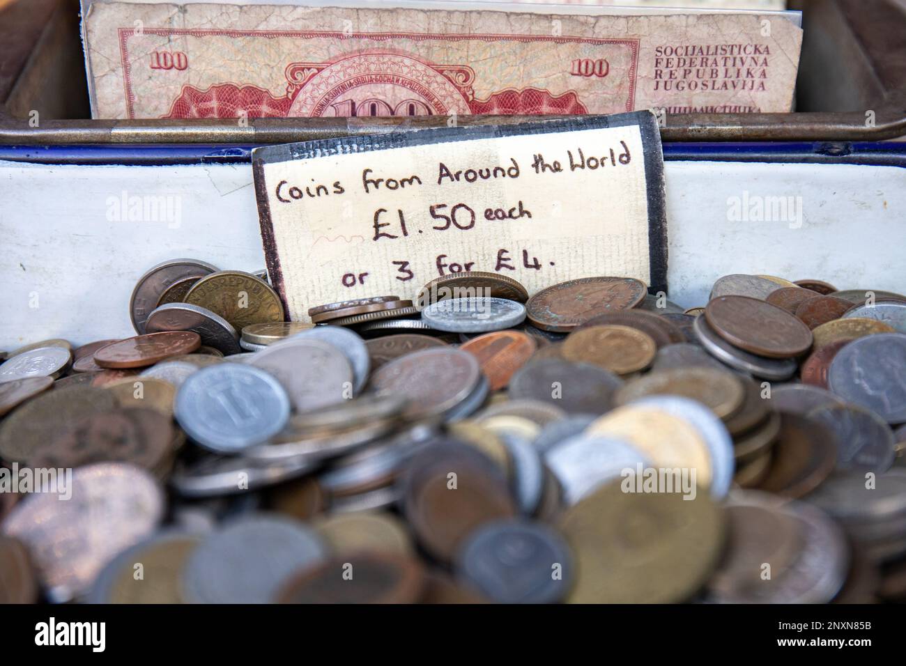 Monete da tutto il mondo. Valuta estera in vendita a Portobello Road nel quartiere Notting Hill di Londra, Inghilterra. Foto Stock