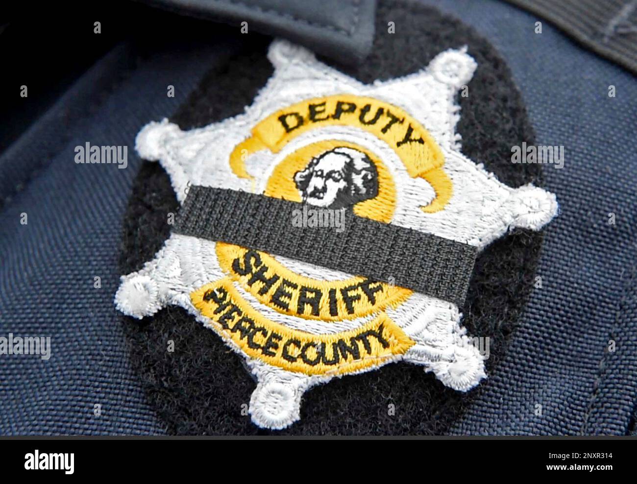 Pierce County sheriff's deputies wore black bars over their badges to