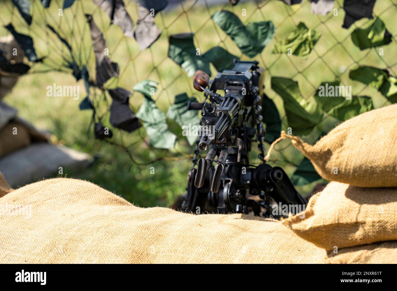 Pistola pesante sovietica NSV con sacchi di sabbia e rete mimetica Foto Stock