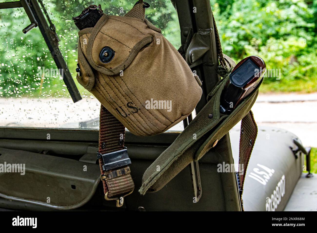 Bottiglia d'acqua e pistola dell'esercito DEGLI STATI UNITI appesi al parabrezza di una jeep militare Foto Stock